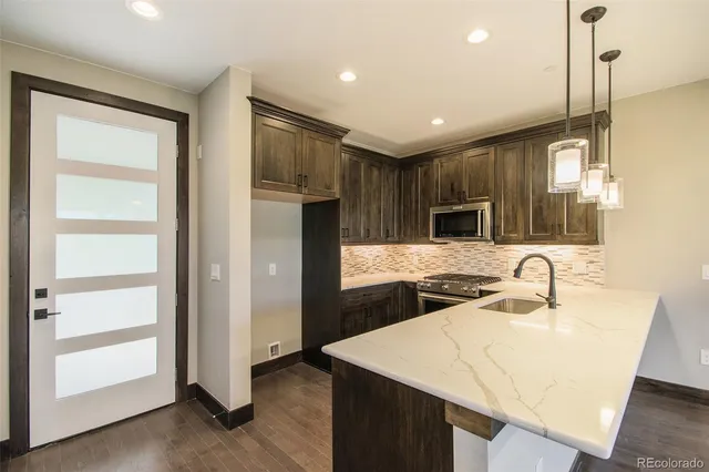 a kitchen with kitchen island a sink stainless steel appliances and cabinets