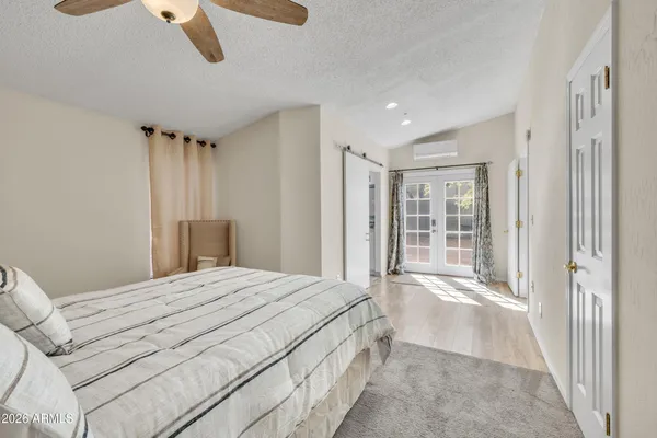 a spacious bedroom with a large bed and a chandelier