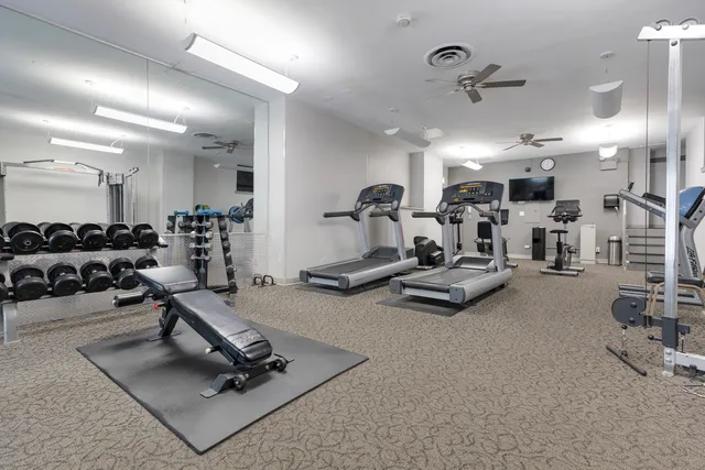 a room with gym equipment and a view of living room
