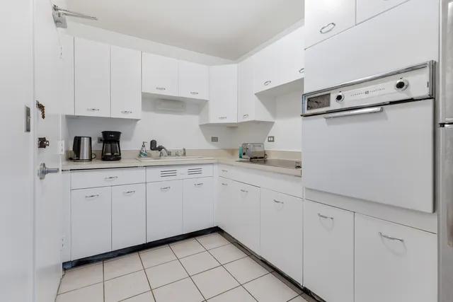 a kitchen with white cabinets and white appliances