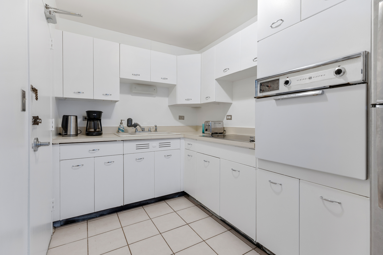 6301 North Sheridan Road, Unit 3A Chicago, IL 60660 - Photo 8 of 22 a kitchen with white cabinets and white appliances