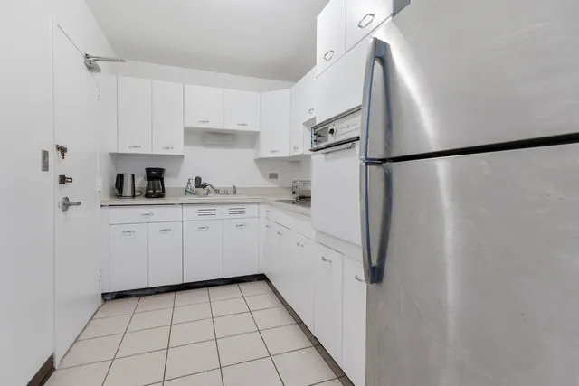 a kitchen with white cabinets a sink and appliances