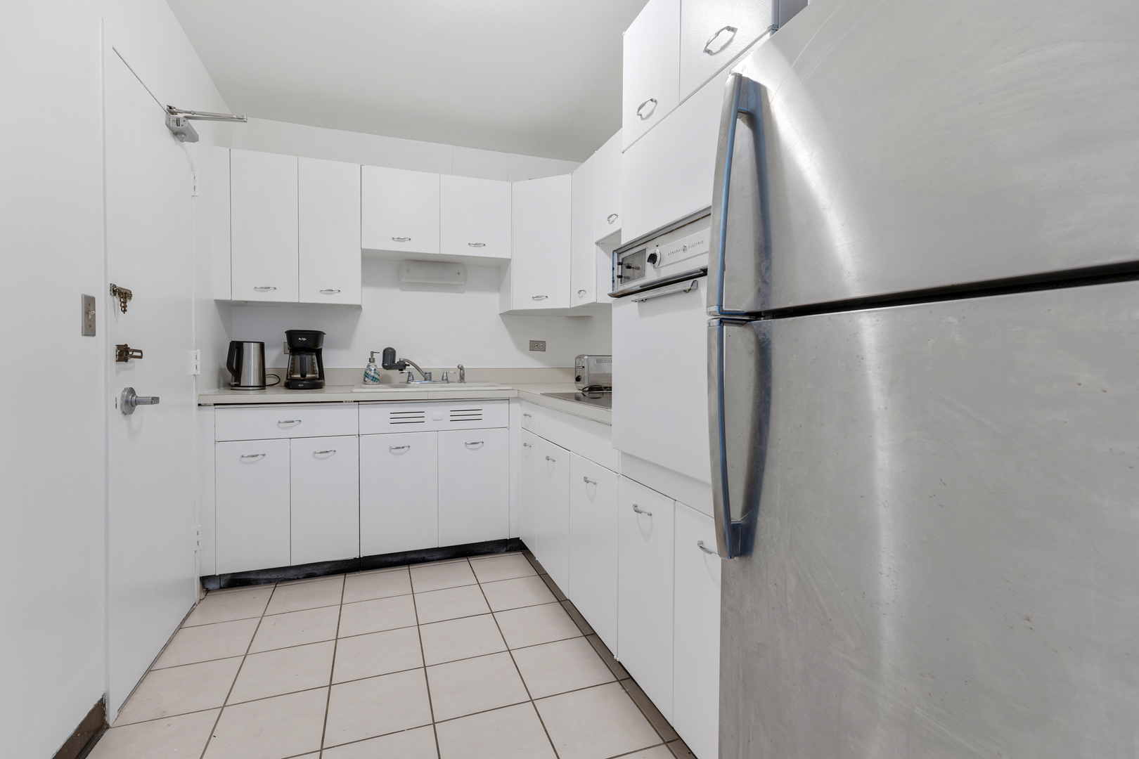 6301 North Sheridan Road, Unit 3A Chicago, IL 60660 - Photo 9 of 22 a kitchen with white cabinets a sink and appliances