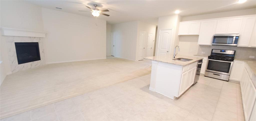 2016 Robert Street Anna, TX 75409 - Photo 3 of 8 a kitchen with stainless steel appliances granite countertop a stove top oven a sink and a refrigerator