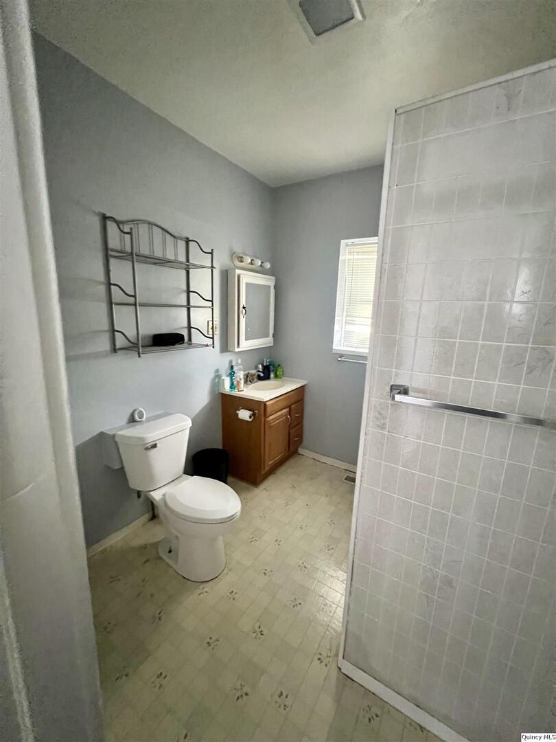 801 Monroe Street Quincy, IL 62301 - Photo 27 of 34 a white toilet sitting next to a bathroom sink and tub