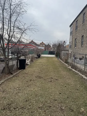 a view of a yard with wooden fence