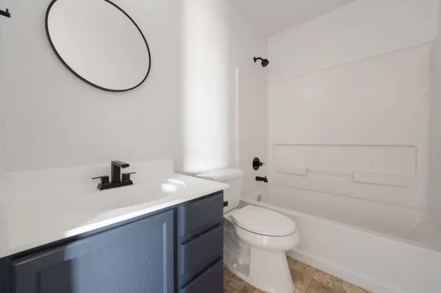 a bathroom with a sink a toilet and a mirror
