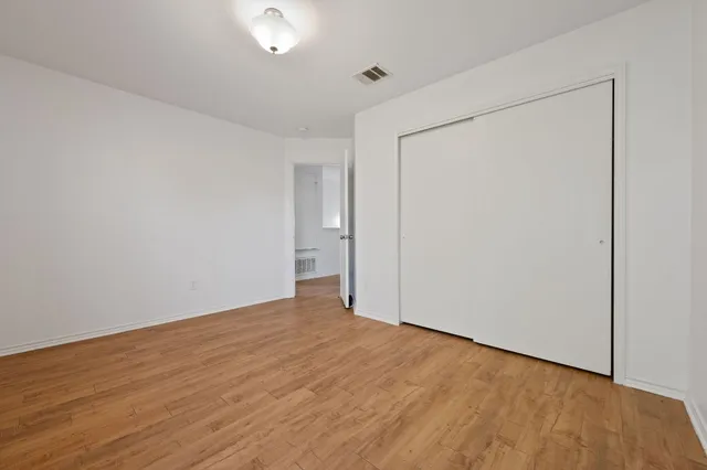a view of an empty room with wooden floor