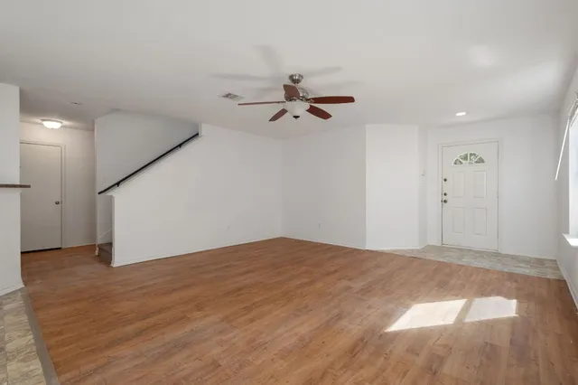 a view of a big room with wooden floor and a ceiling fan