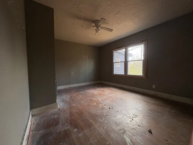 en empty room with windows and ceiling fan
