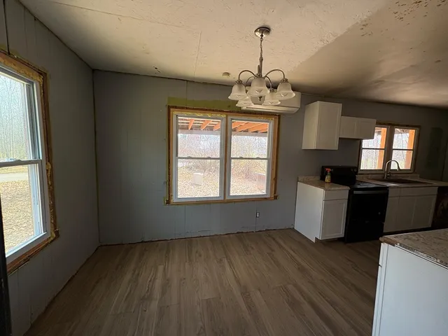 a view of a kitchen with a sink wooden floor and a window