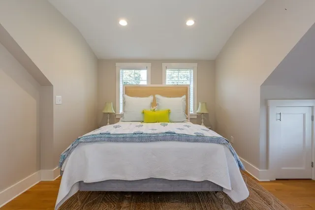 a bedroom with a bed and wooden floor