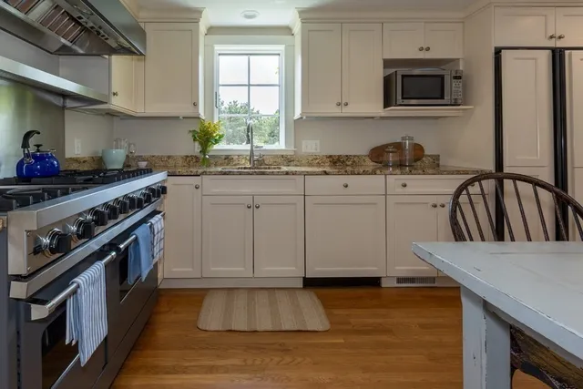 a kitchen with granite countertop a stove sink and cabinets