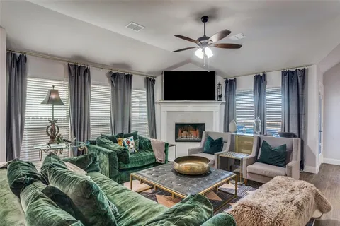 a living room with furniture a fireplace and a flat screen tv