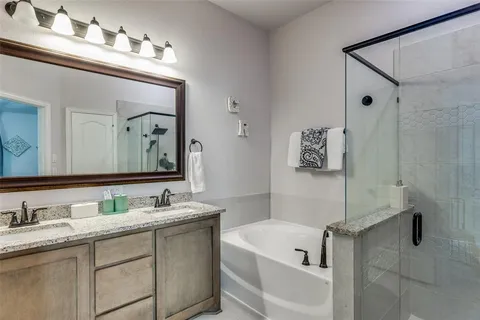 a bathroom with a tub a sink and mirror