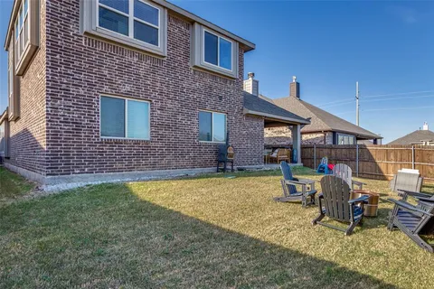a view of a house with backyard and chairs