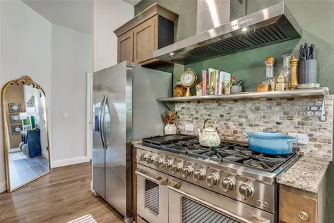 a kitchen with stainless steel appliances granite countertop a stove and a refrigerator