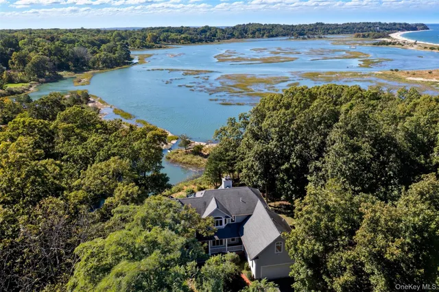 an aerial view of ocean with residential house and outdoor space