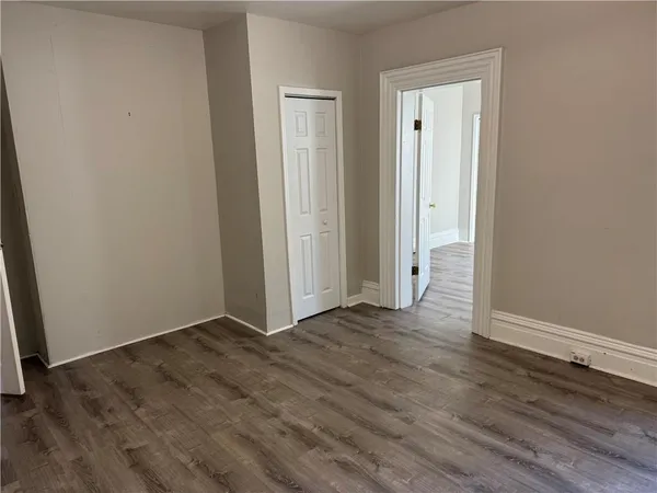 a view of an empty room with wooden floor