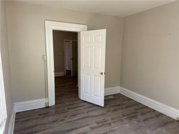 an empty room with wooden floor & closet