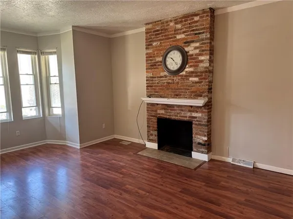 an empty room with wooden floor and fireplace