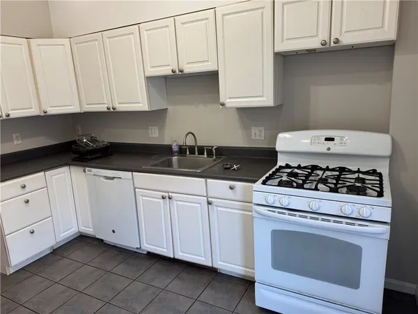 a white kitchen stove with white cabinets