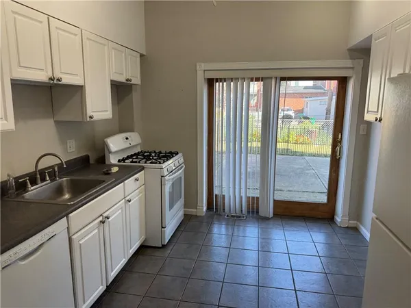 a kitchen with a sink a refrigerator and cabinets