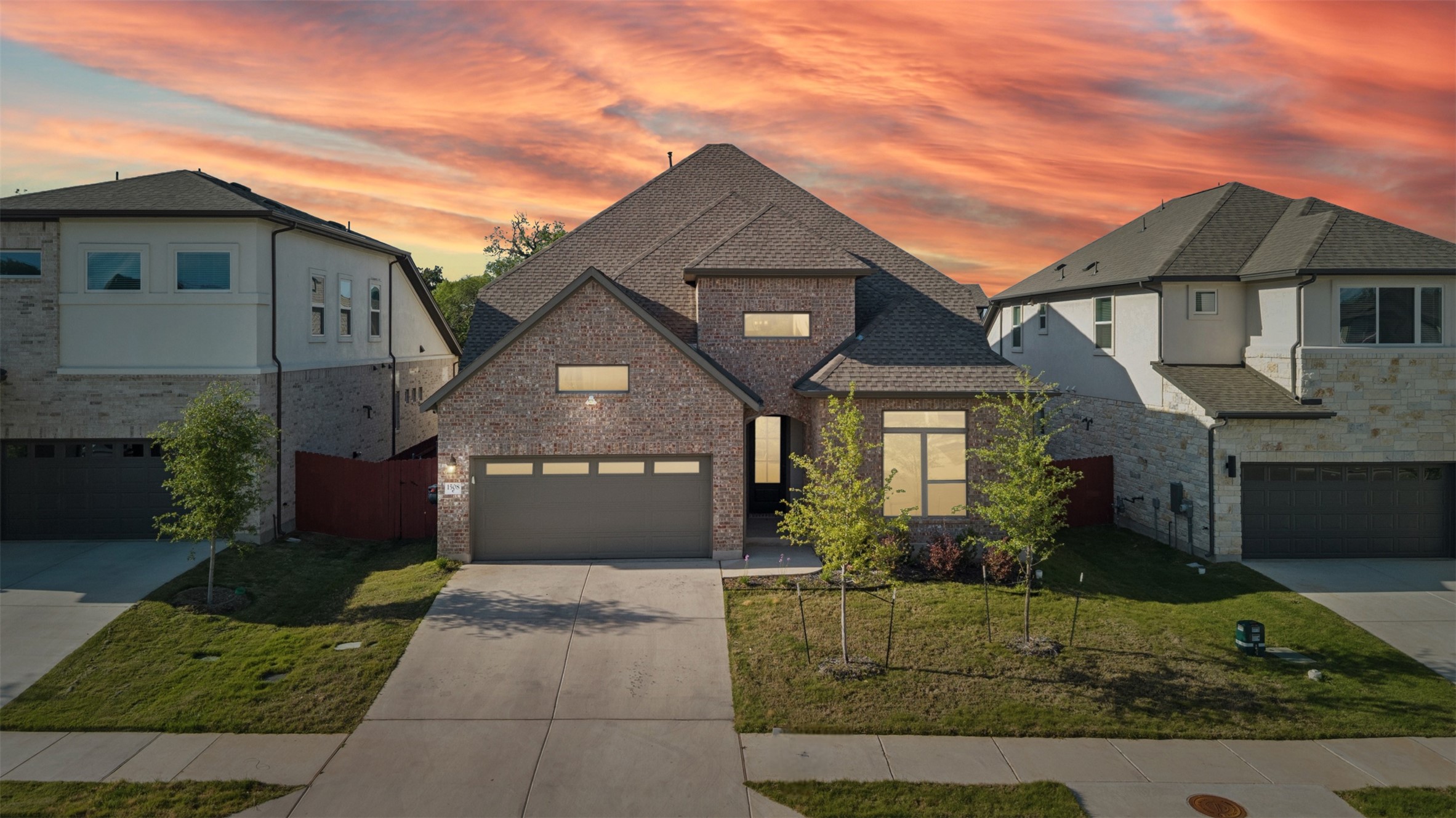 French provincial home featuring driveway, stone siding, a front lawn, and a shingled roof