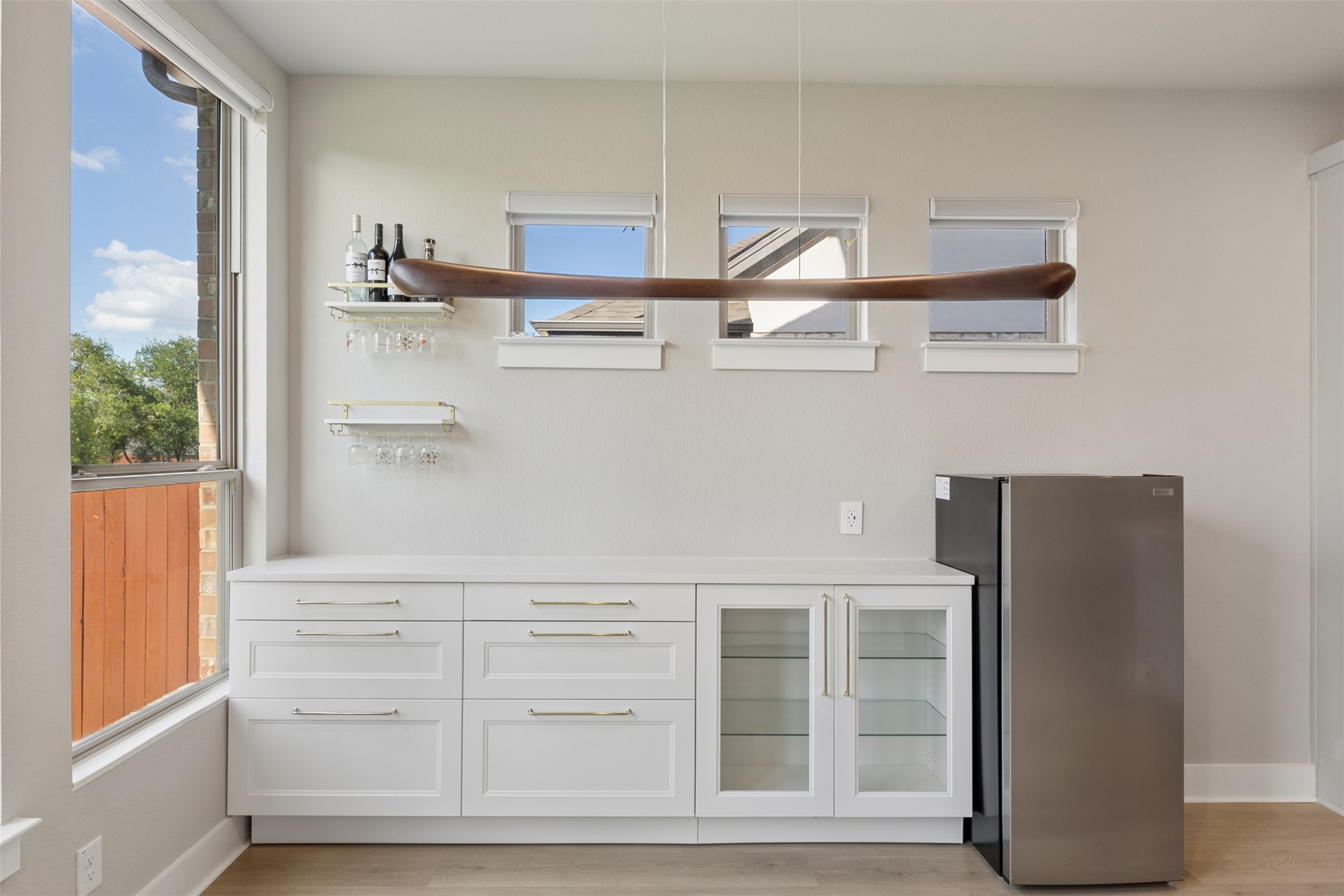 1508 Cardinal Lane Round Rock, TX 78681 - Photo 12 of 35 Bar with open shelves, freestanding refrigerator, white cabinets, light wood finished floors, and healthy amount of natural light