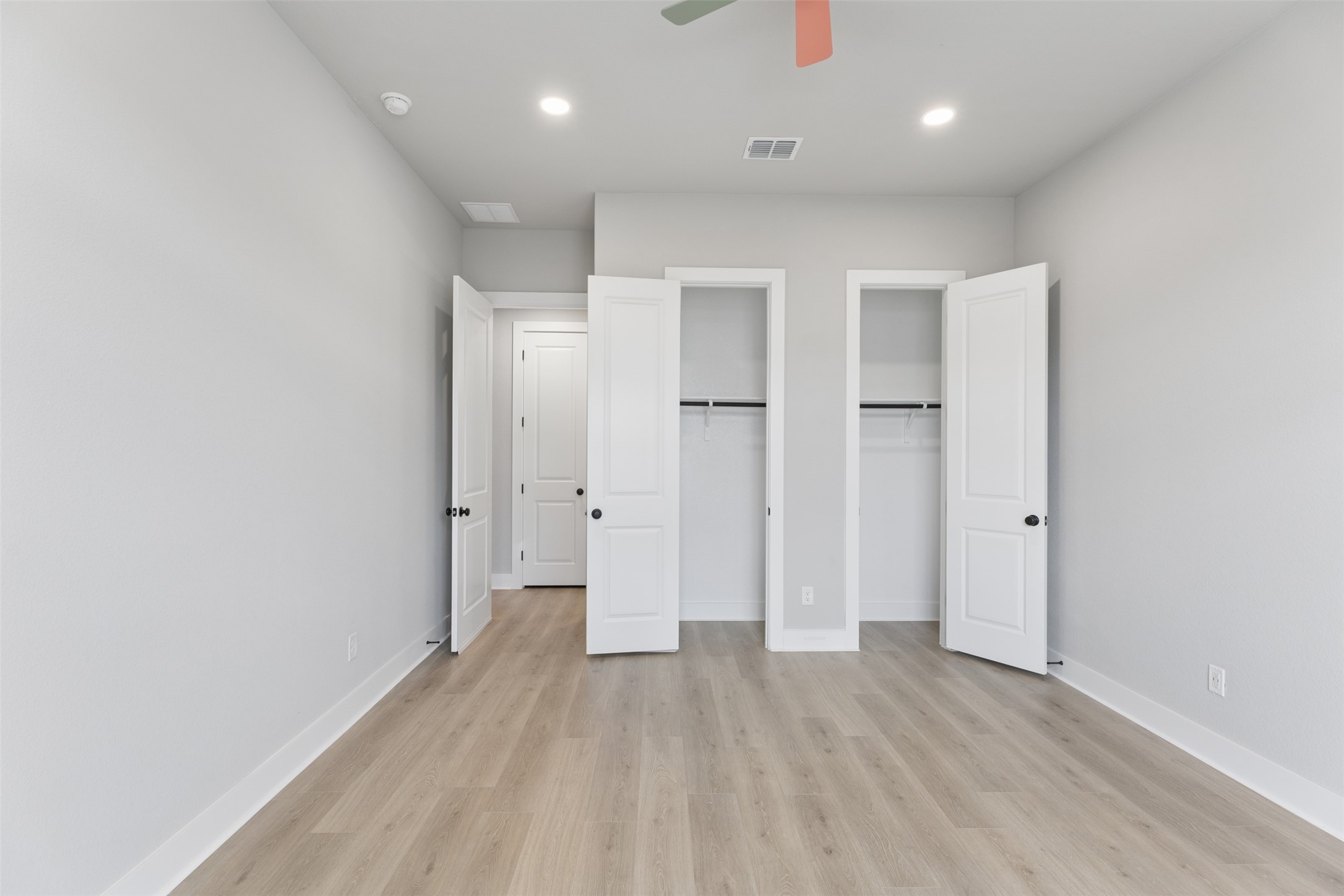 1508 Cardinal Lane Round Rock, TX 78681 - Photo 14 of 35 Unfurnished bedroom with multiple closets, light wood finished floors, recessed lighting, and a ceiling fan