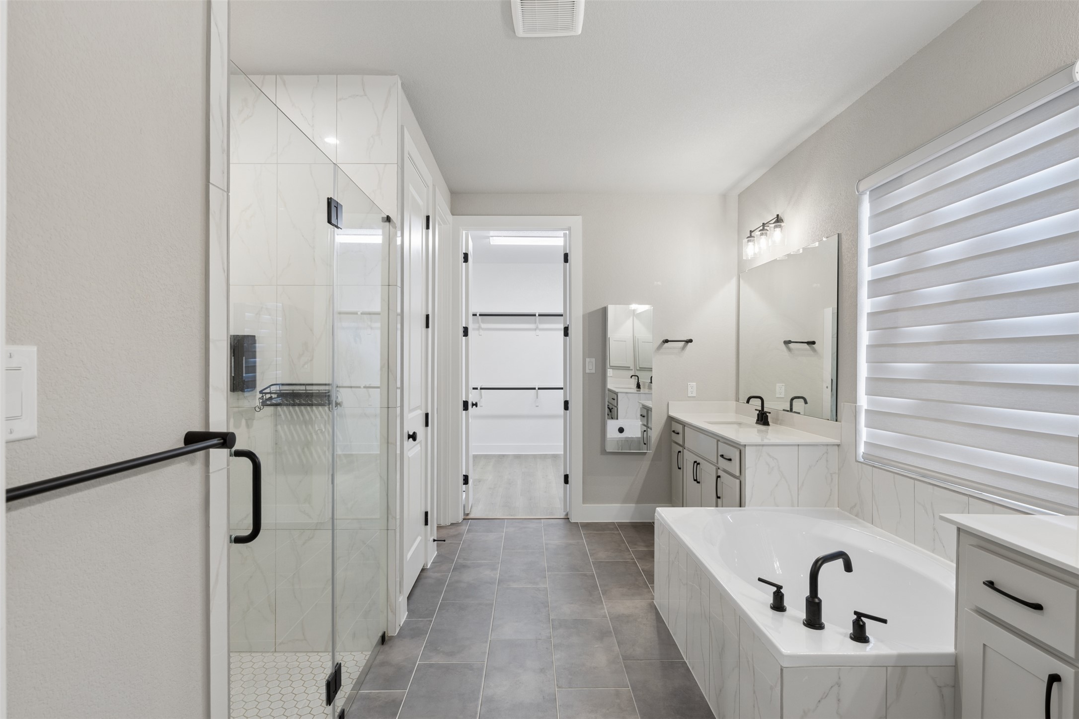 1508 Cardinal Lane Round Rock, TX 78681 - Photo 20 of 35 Full bath featuring vanity, a shower stall, a garden tub, a walk in closet, and dark tile patterned flooring