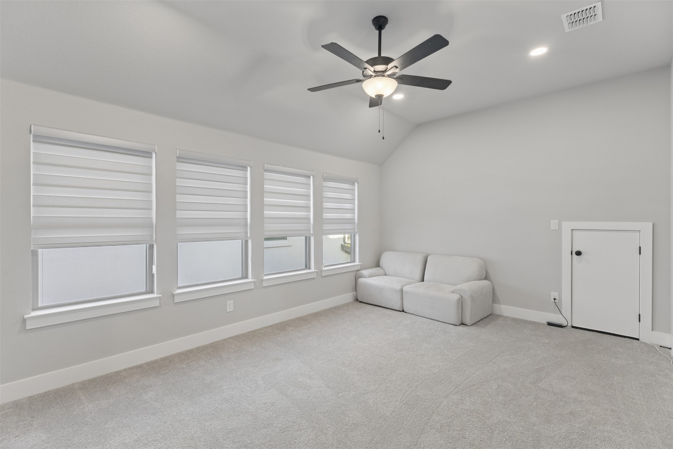 1508 Cardinal Lane Round Rock, TX 78681 - Photo 24 of 35 Unfurnished room with light colored carpet, lofted ceiling, ceiling fan, and recessed lighting