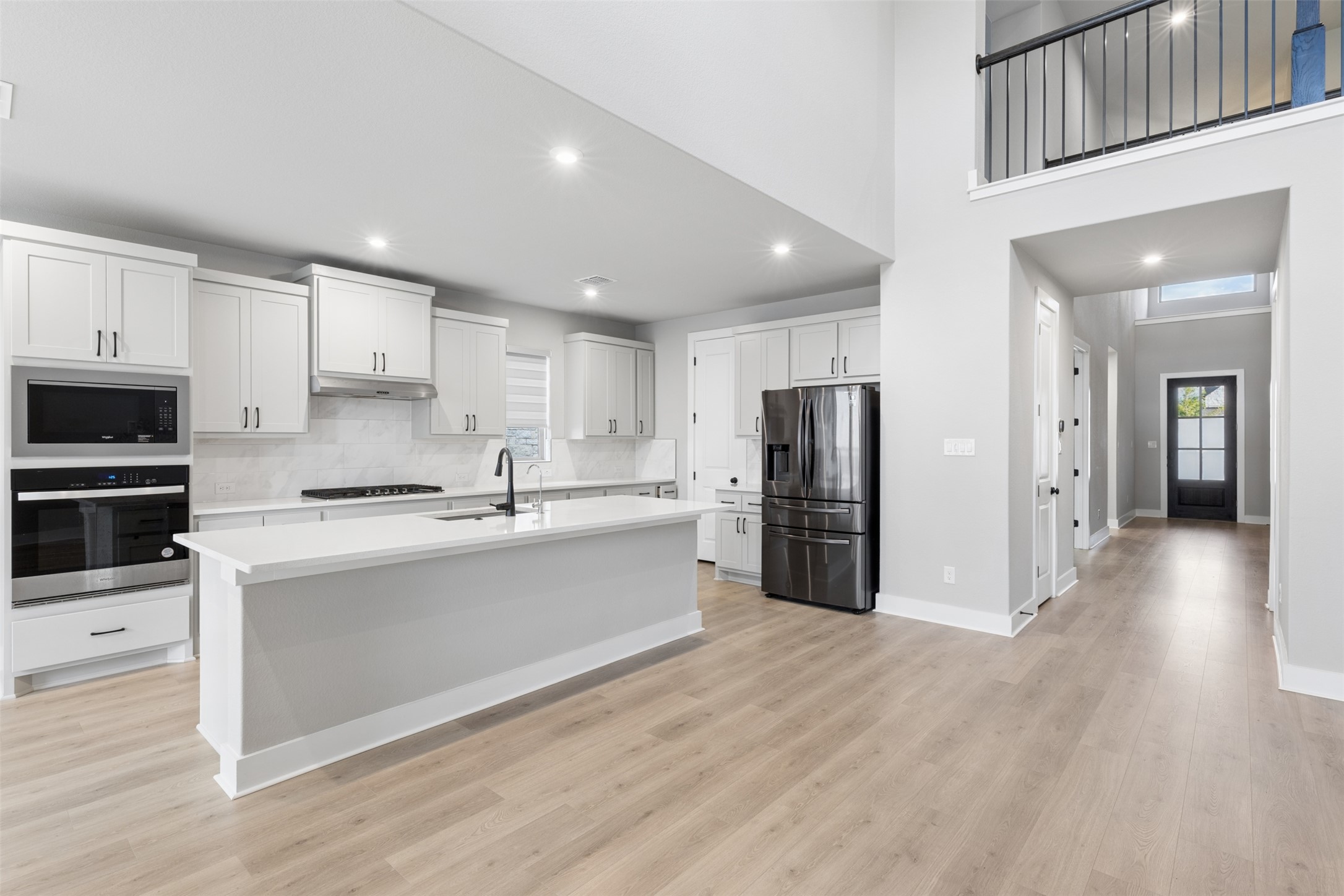 1508 Cardinal Lane Round Rock, TX 78681 - Photo 4 of 35 Kitchen featuring stainless steel appliances, an island with sink, white cabinets, light wood-type flooring, and recessed lighting