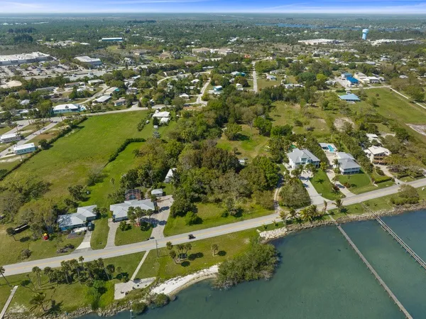 an aerial view of residential houses with outdoor space and trees