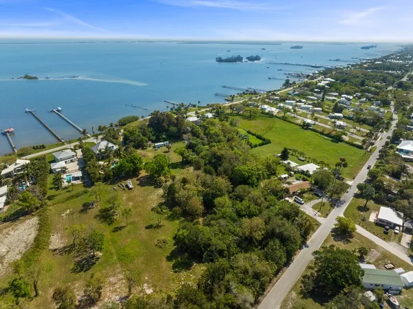 an aerial view of residential houses with outdoor space and trees