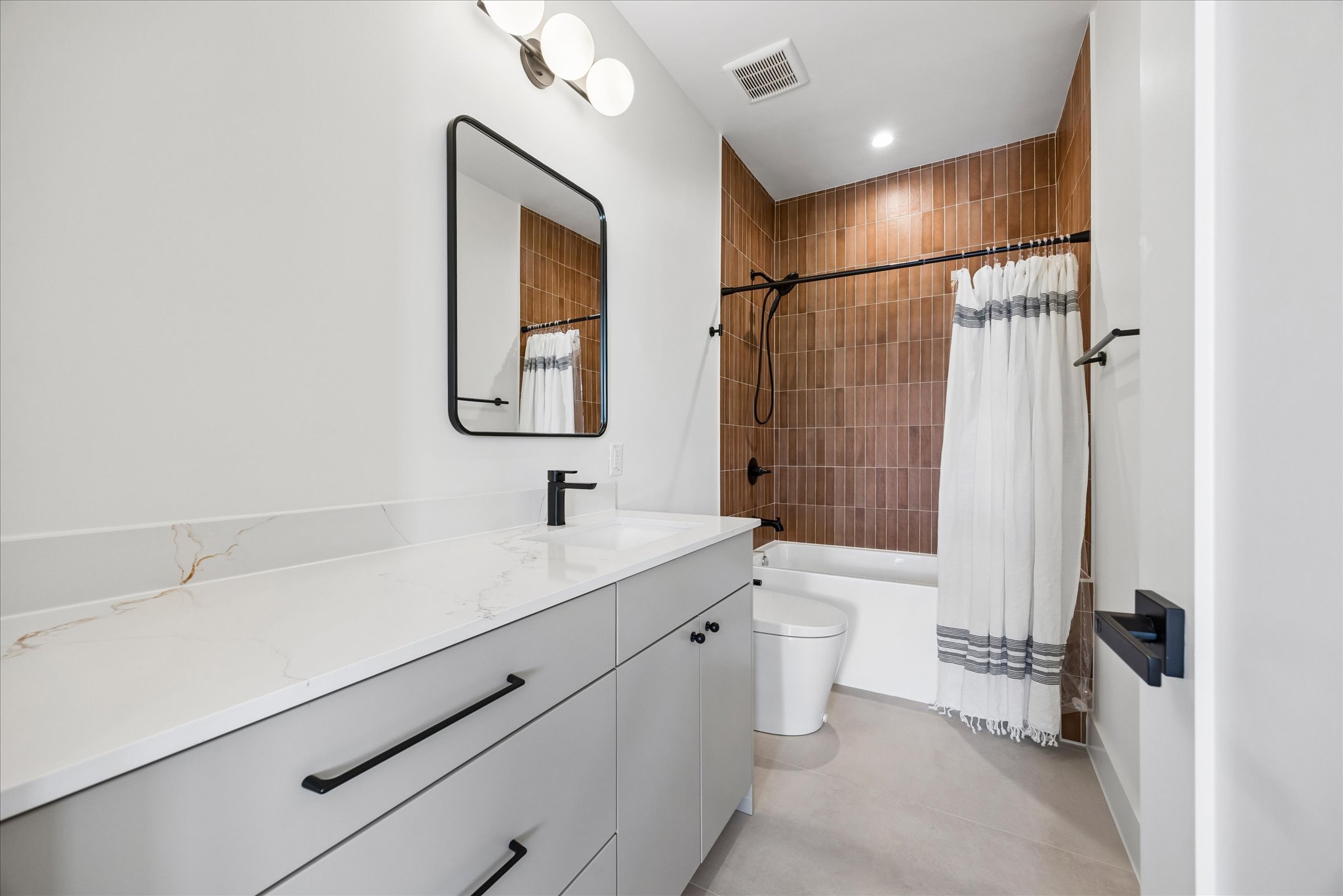 4416 South 1st Street, Unit 2 Austin, TX 78745 - Photo 22 of 33 a bathroom with a double vanity sink toilet mirror and shower