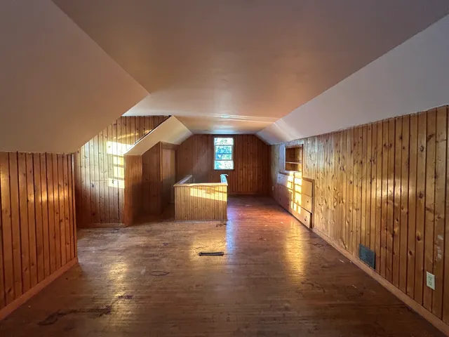 a view of a hallway with wooden floor and windows