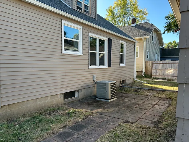 a view of a patio with a table and chairs and wooden fence