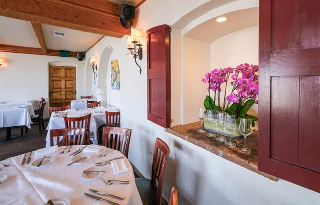 a dining room with furniture and flowers