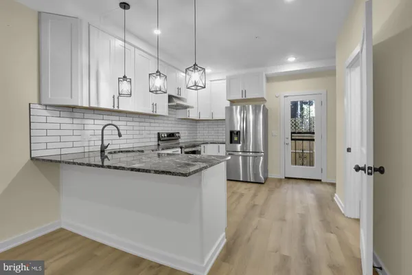 a kitchen with stainless steel appliances granite countertop a sink refrigerator and cabinets