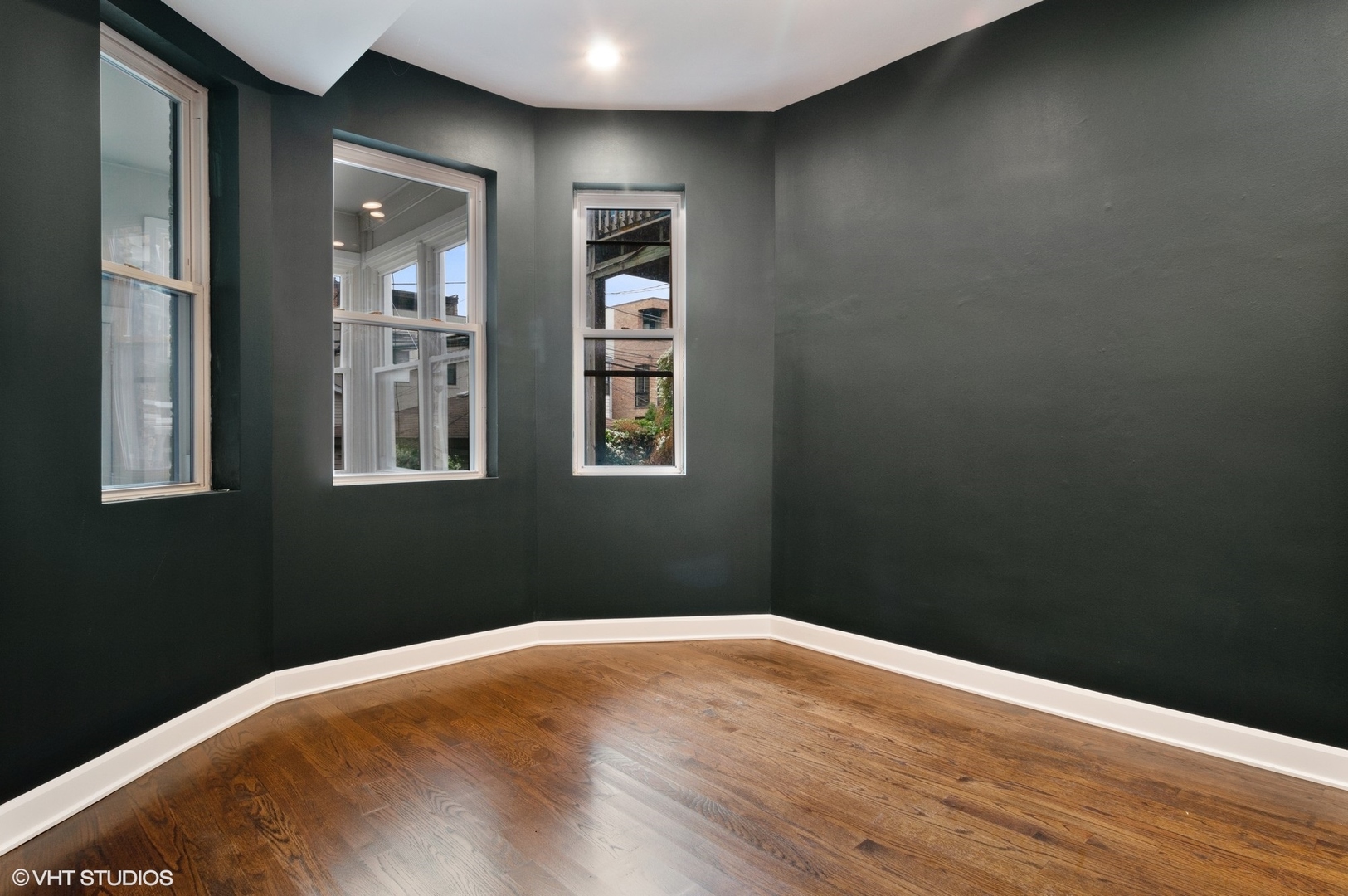 1211 West Addison Street, Unit 2 Chicago, IL 60613 - Photo 12 of 16 a view of an empty room with wooden floor and a window