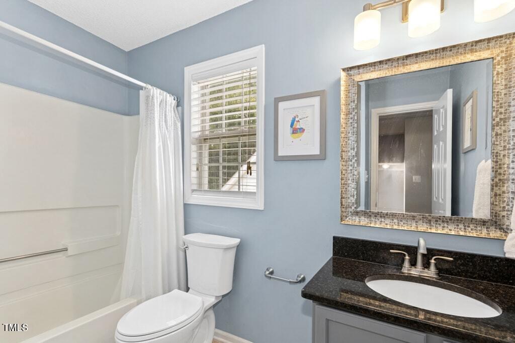2342 School Creek Place Raleigh, NC 27606 - Photo 26 of 41 a bathroom with a granite countertop sink toilet a mirror and shower
