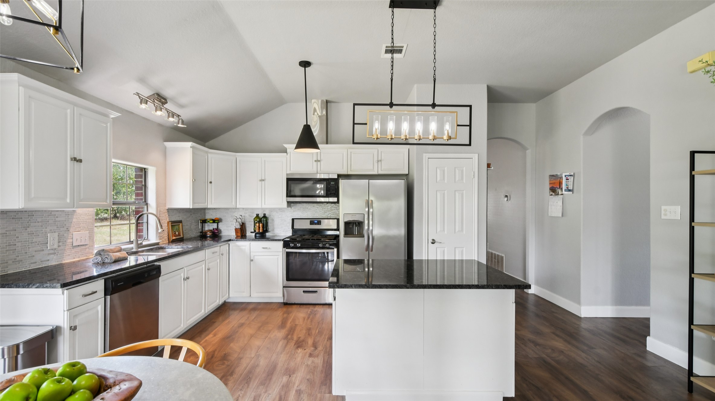 13131 Crane Road Buda, TX 78610 - Photo 9 of 18 a kitchen with stainless steel appliances granite countertop a refrigerator a sink dishwasher a stove and white cabinets with wooden floor
