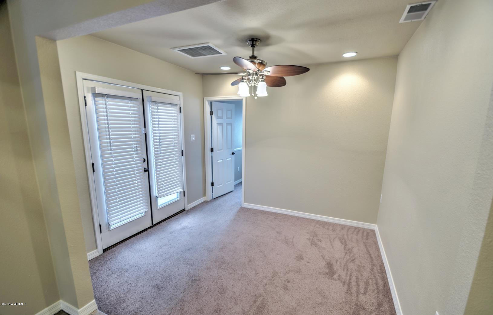 4211 East Carson Road Phoenix, AZ 85042 - Photo 12 of 19 an empty room with a ceiling fan and a window