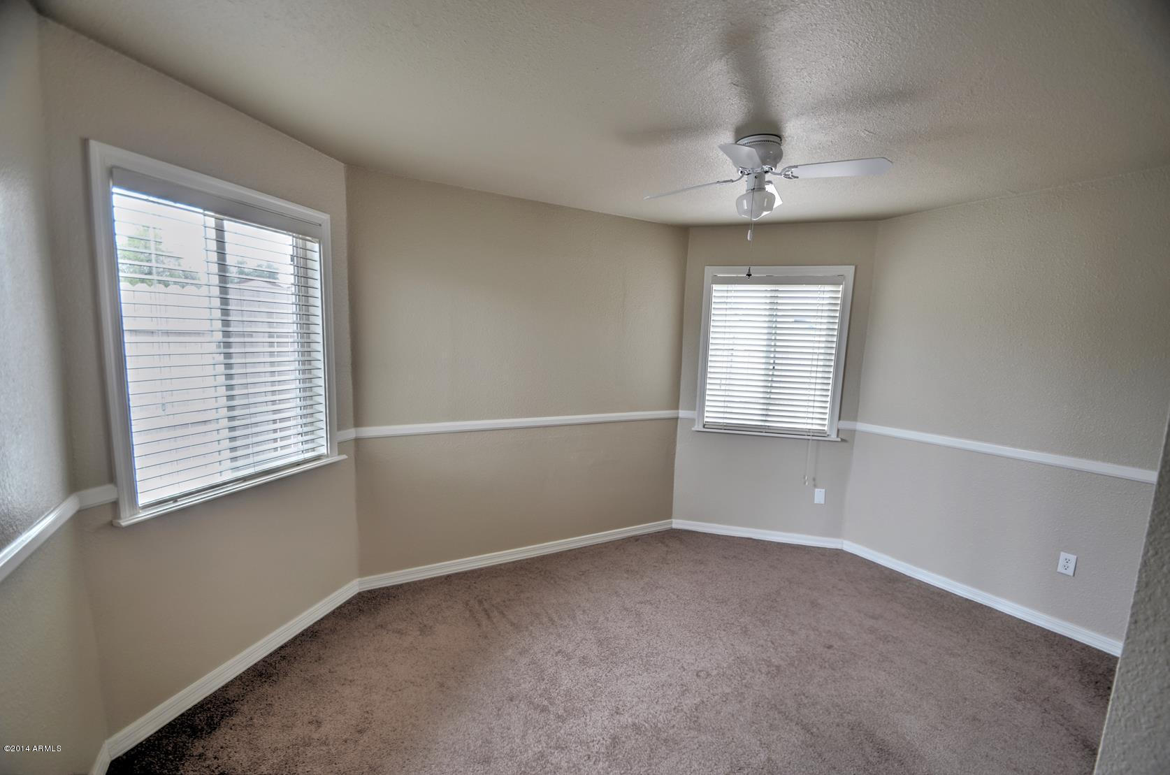 4211 East Carson Road Phoenix, AZ 85042 - Photo 15 of 19 an empty room with a window and chandelier fan