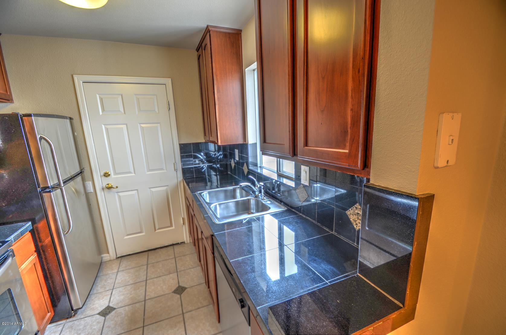 4211 East Carson Road Phoenix, AZ 85042 - Photo 10 of 19 a kitchen with a sink and a refrigerator