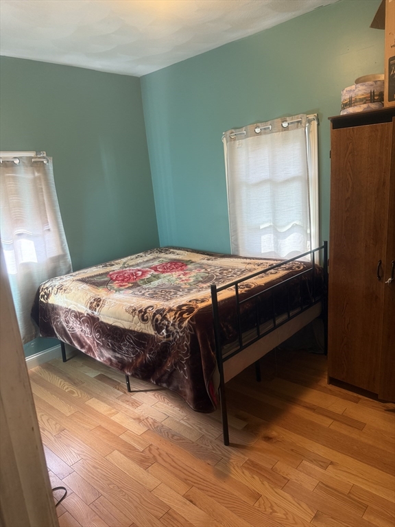 82 2nd Street Medford, MA 02155 - Photo 17 of 23 a bedroom with a bed and wooden floor