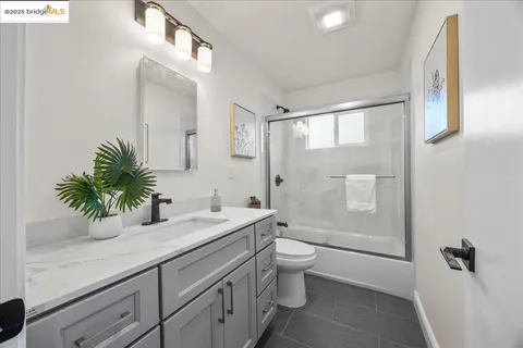 a bathroom with a sink a toilet a shower and a mirror