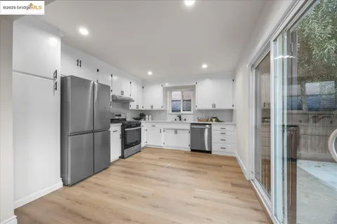 a kitchen with stainless steel appliances granite countertop a refrigerator and a sink