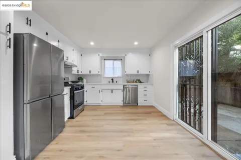 a view of a backyard with large trees and wooden fence